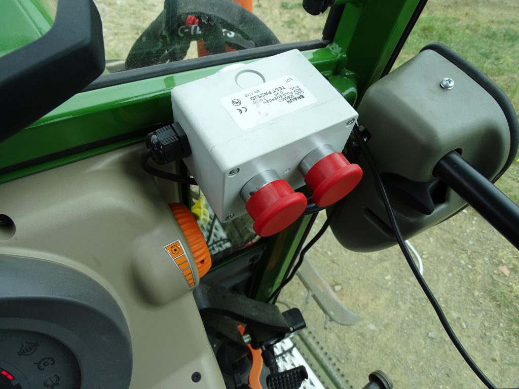 V kabini traktorja je nameščena komandna omarica z dvema rdečima gumboma - stikaloma za aktiviranje ročnega odmika podrezovalnika LUV Perfekt. 